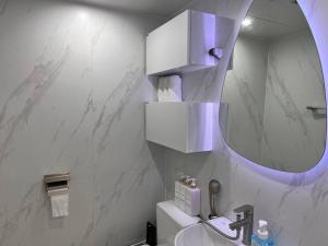 W białej łazience znajduje się umywalka i lustro. w obiekcie Terrace with Walking Trail Room 304 w mieście Suncheon