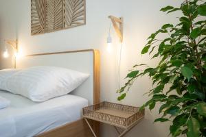 ein Schlafzimmer mit einem Bett mit einer Pflanze daneben in der Unterkunft Bright and cozy studio with a city view in Wien