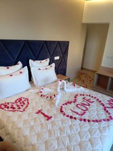 a large bed with heart decorations on it at Appart Hôtel Pyramides El Jadida in El Jadida