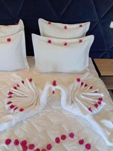 a bed with two swans made out of white sheets at Appart Hôtel Pyramides El Jadida in El Jadida