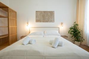 ein großes weißes Bett mit weißen Kissen darauf in der Unterkunft Bright and cozy studio with a city view in Wien
