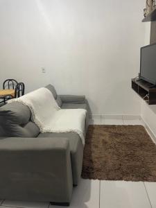 uma sala de estar com um sofá e uma televisão em Casa 01,02 em Bombinhas