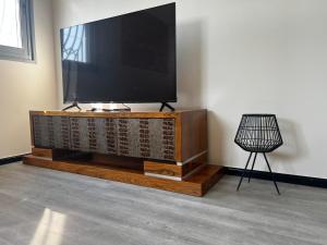 a flat screen tv on top of a wooden entertainment center at Open-space apartment by the SEA in Ashdod