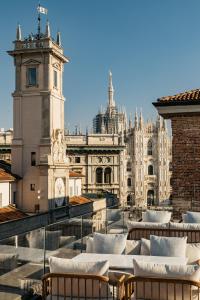 a view of a building with chairs and a clock tower at Palazzo Cordusio, a Gran Melia Hotel in Milan