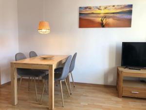 une salle à manger avec une table, des chaises et une télévision dans l'établissement Am Mühlenbach - ABC270, à Wismar