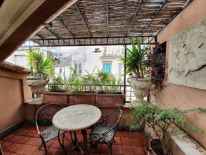 einen Balkon mit einem Tisch, Stühlen und Pflanzen in der Unterkunft Hotel OKAPI in Rom