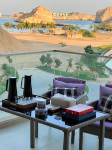 een woonkamer met een tafel en uitzicht op de woestijn bij W muscat bay in Muscat