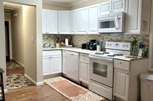 uma cozinha com armários brancos e um forno com placa de fogão em Niagara Apartment em Niagara Falls