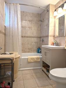 uma casa de banho com uma banheira, um WC e um lavatório. em Niagara Apartment em Niagara Falls