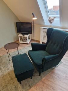 a living room with a couch and a chair and a tv at Atelier unterm Marienturm - ABC351 in Wismar