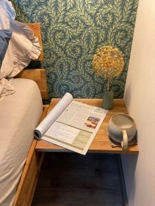 a wooden table with a book and a flower vase on it at Atelier unterm Marienturm - ABC351 in Wismar