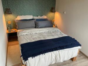 a bedroom with a bed with a blue blanket on it at Atelier unterm Marienturm - ABC351 in Wismar +12 photos