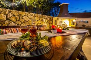 una mesa con dos copas de vino y un plato de comida en Villa Maggie Alonia, en Méson Yerakaríon