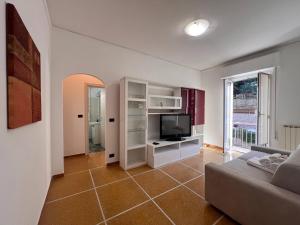 een woonkamer met een bank en een televisie bij Relax & Mare in Rapallo