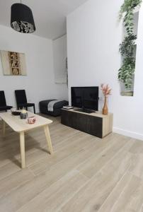 Una sala de estar con una mesa y un televisor. en Fantástico piso nuevo, Mentidero, en Cádiz 26 fotos más