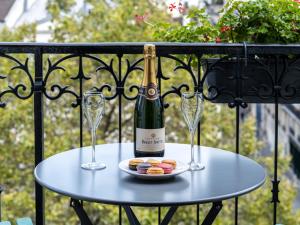 un tavolo con due bicchieri e una bottiglia di vino di Hotel Minerve a Parigi
