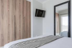 a bedroom with a bed with a mirror and a tv at Pax's Breathtaking Apartment - The Blyde-Beach in Pretoria +7 photos