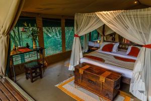 Soroi Mara Bush Camp في ماساي مارا: غرفة نوم بسرير ومكتب في خيمة
