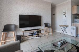 a living room with a flat screen tv on a wall at Pax's Breathtaking Apartment - The Blyde-Beach in Pretoria
