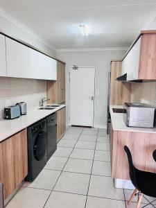 a kitchen with a washer and a sink and a stove at The Blyde in Pretoria