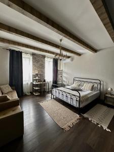 een slaapkamer met een bed en een bank bij REDROOF country house hotel in Goris
