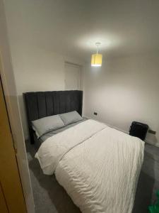 a bedroom with a large bed with white sheets at 2bedroom apartment/steam room in Carnoustie