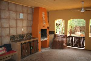 a living room with a fireplace in the middle of a room at Kiburi Lodge @ Kruger, a secluded Bushveld getaway in Marloth Park