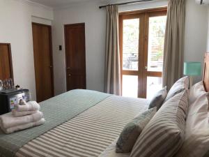 a bedroom with a bed with towels on it at Casa Arrayán in Santiago