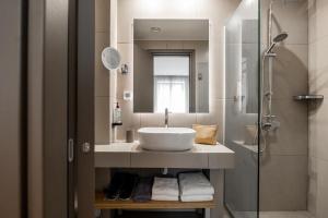 uma casa de banho com um lavatório e um chuveiro em Pnoe Urban Living em Atenas