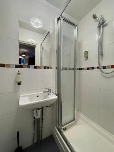 a white bathroom with a shower and a sink at Single Bright Studio Flat in King's Cross in London