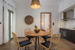 una mesa de comedor con sillas y un bol de fruta. en Casa 28 City Apartments, en La Canea