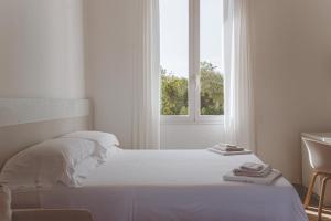 オートラントにあるResidence Altair - Serra Degli Alimini 3の白いベッドルーム(ベッド1台、窓付)