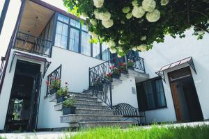ein weißes Gebäude mit Treppen und Topfpflanzen in der Unterkunft REDROOF country house hotel in Goris
