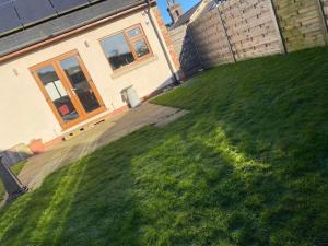 a yard with a house and a green lawn at The Barn in Haxby