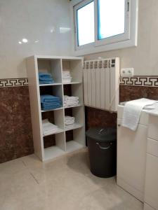 uma casa de banho com WC e uma prateleira com toalhas em Apartamento independiente en plena naturaleza Vallromanes Barcelona em Vallromanes
