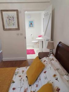 a bedroom with a bed with a flower patterned blanket at Astella Lodge. in West Quantoxhead