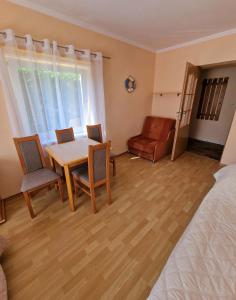 a room with a table and chairs and a bed at Dom Gościnny Roksana in Rewal