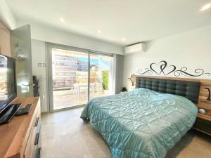 a bedroom with a bed and a television and a balcony at Maryline by Welcome to Cannes in Cannes