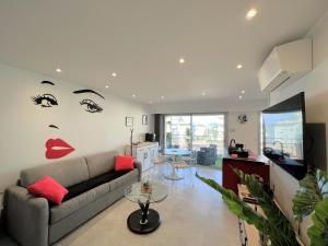 a living room with a couch with a face painted on the wall at Maryline by Welcome to Cannes in Cannes