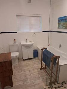 a bathroom with a toilet and a sink and a tub at Sunshine Cottage in Pennington