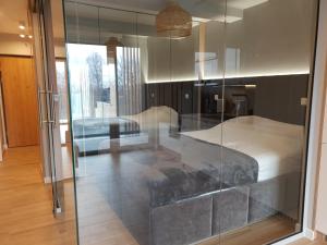 a bedroom with a bed through a glass window at Apartament Laguna Beskidów - Zarzecze in Zarzecze