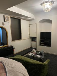 een kamer met een bed, een tv en een bank bij ロビンホテルRobin Hotel in Yachimata
