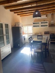 eine Küche mit einem Tisch und Stühlen sowie einem Kühlschrank in der Unterkunft CASA QUINTA in San Juan