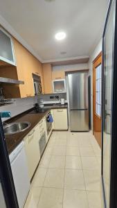 a kitchen with a sink and a refrigerator at Apartamento en Altea con vistas al mar in Altea