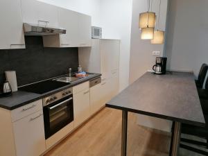 een keuken met witte kasten, een wastafel en een aanrecht bij Cityflair Nähe Marktplatz - ABC328 in Wismar