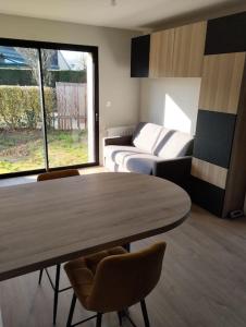 a room with a table and a bed and a couch at Studio tout neuf proche Rennes in Saint-Grégoire