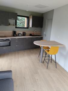 a kitchen with a table and chairs in a room at Studio tout neuf proche Rennes in Saint-Grégoire