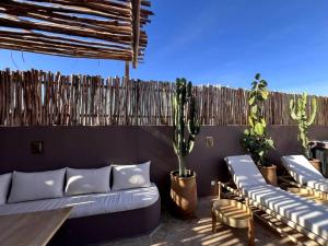a patio with couches and potted plants and a fence at RIAD LE M neuf et contemporain in Marrakech