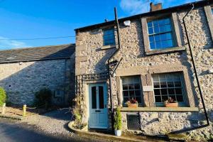 a stone house with a blue door and windows at Fabulous Folds Cottage in Curbar