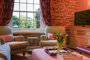 a living room with a vase of flowers on a table at Fabulous Folds Cottage in Curbar